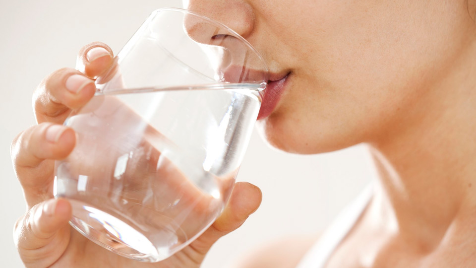 Mujer bebiendo agua de un vaso