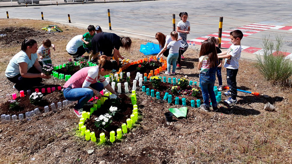 Niños y adultos sembrando y trasplantando plantas