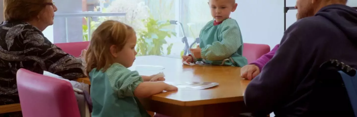 Personas mayores y niños comiendo juntos en una mesa