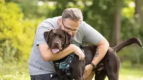 Hombre abrazando a su perro
