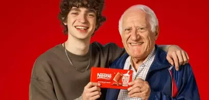 Adolescente junto a su abuelo mostrando una tableta de chocolate Nestlé Extrafino