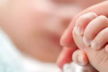 Madre sujetando la mano de su bebé