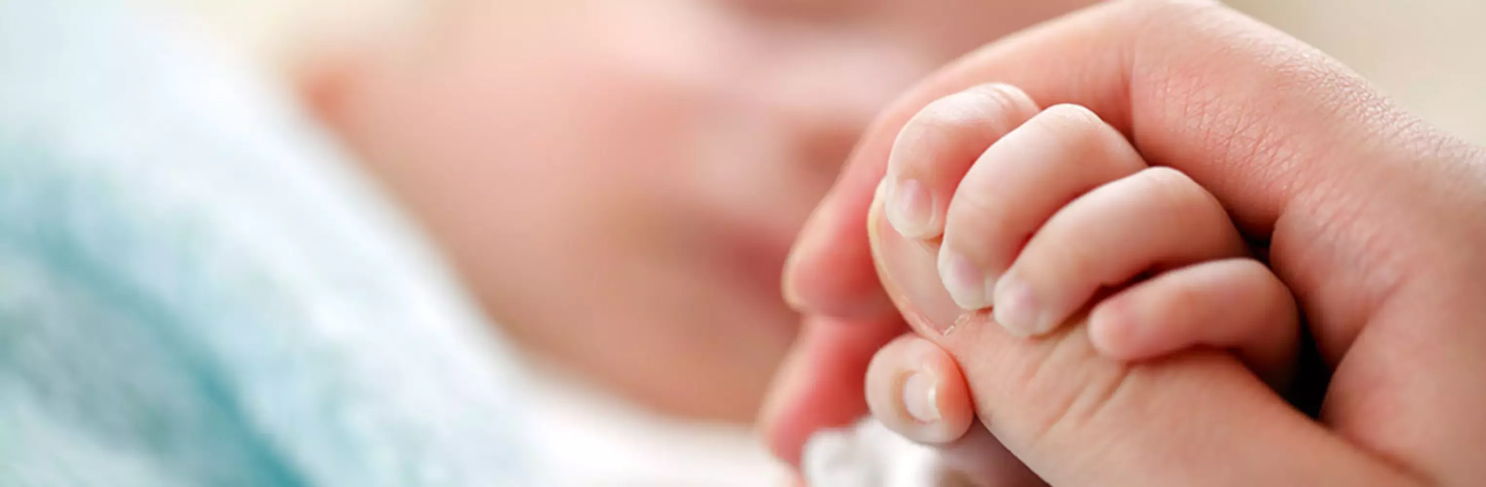 Madre sujetando la mano de su bebé