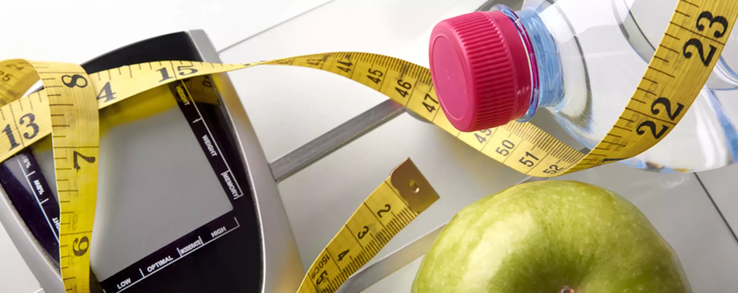 Cinta métrica, agua y manzana