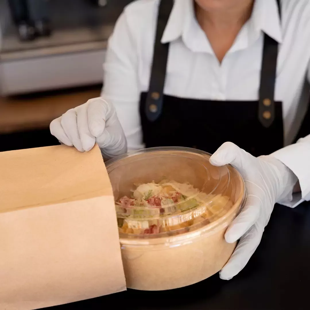 Persona guarando comida en una bolsa para llevar