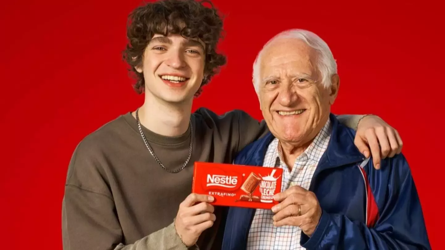Adolescente junto a su abuelo mostrando una tableta de chocolate Nestlé Extrafino