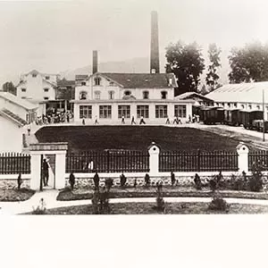 histórica de una fábrica de Nestlé con edificios industriales y chimenea al fondo
