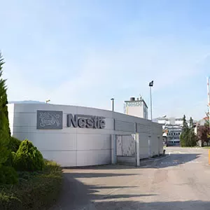 Entrada de una fábrica de Nestlé con edificio corporativo y acceso principal