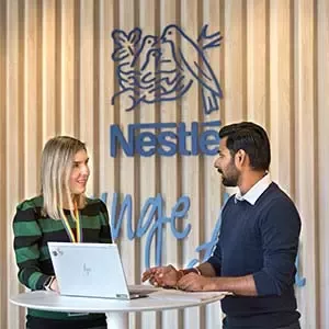 Dos empleados colaborando en un espacio de trabajo corporativo de Nestlé