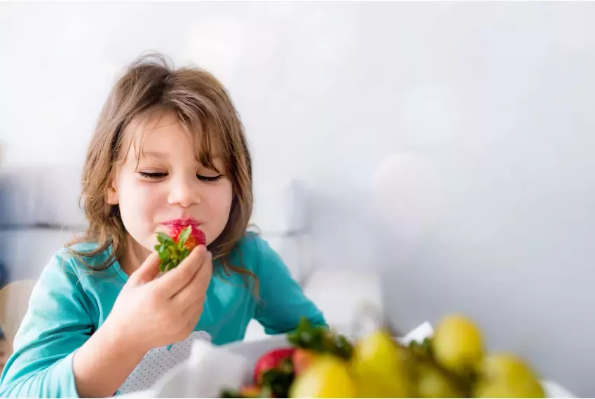 Niño comiendo fresas
